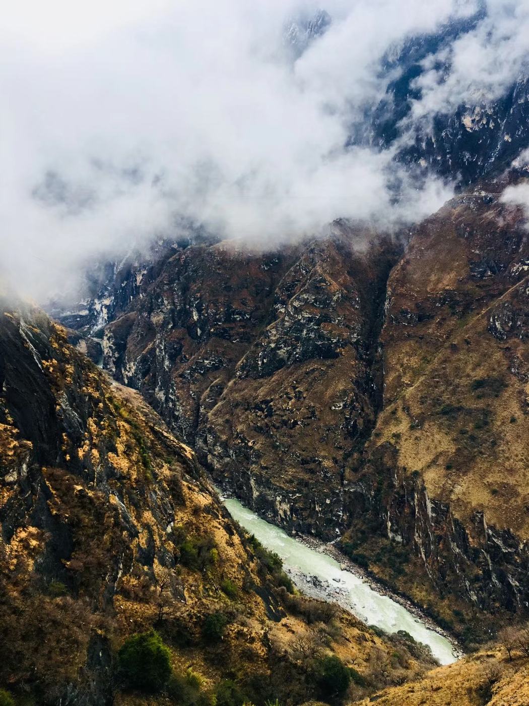The river winding through the gorge with clouds drifting over the slopes