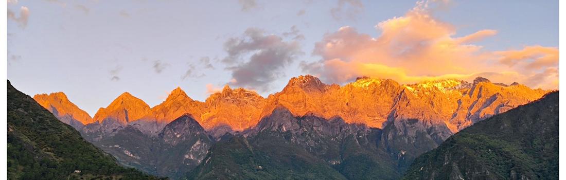 The Jade Dragon range glowing orange under a pink cloud